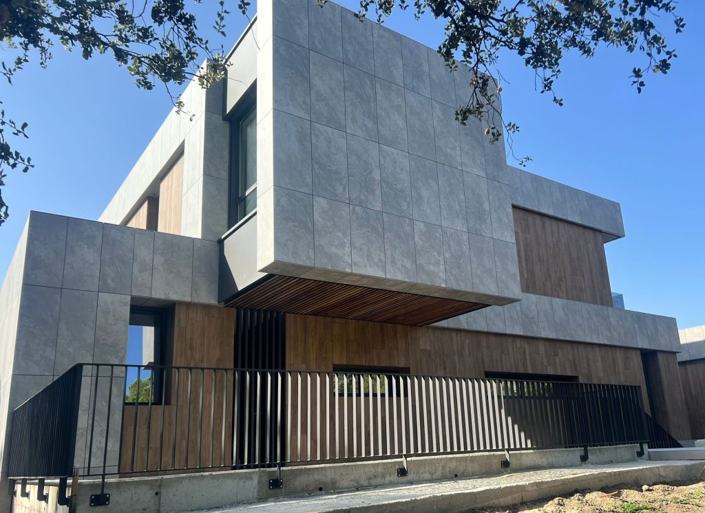 Fachada ventilada moderna con acabados en piedra y madera